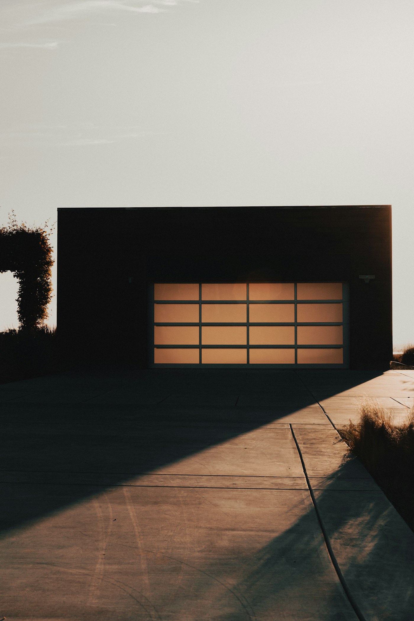 Warm-lit modern garage door at dusk — the kind of stuck or off-track call we answer same day in the East Bay